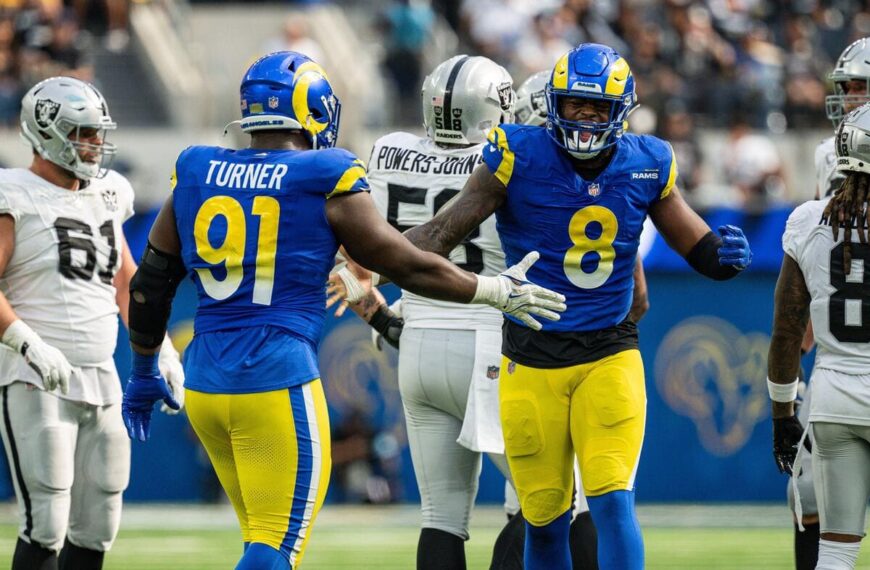 Los Angeles Rams defensive linemen Kobie Turner and Jared Verse high-fiving.