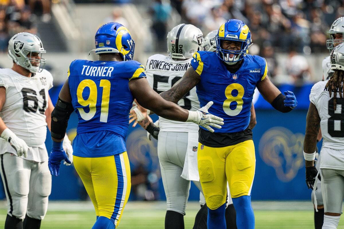 Los Angeles Rams defensive linemen Kobie Turner and Jared Verse high-fiving.