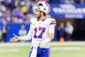 Buffalo Bills quarterback Josh Allen with his helmet off looking upset.