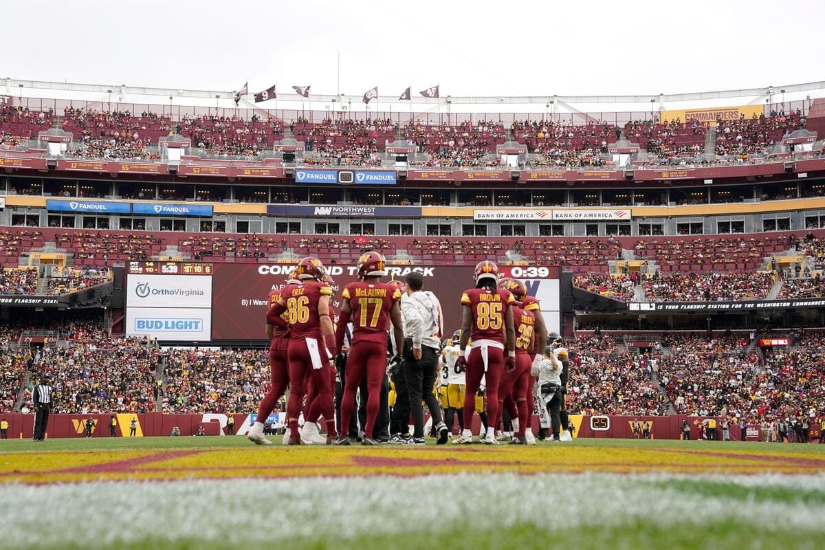 Members of the Washington Commanders offense huddled together during a game-break.