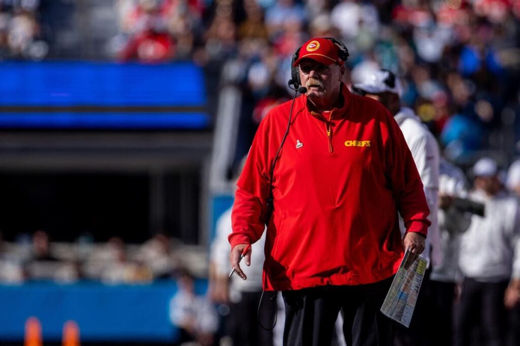 Kansas City Chiefs coach Andy Reid on the sideline during a game holding a playsheet.