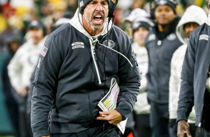 San Francisco 49ers head coach yelling on the sideline of a football game.