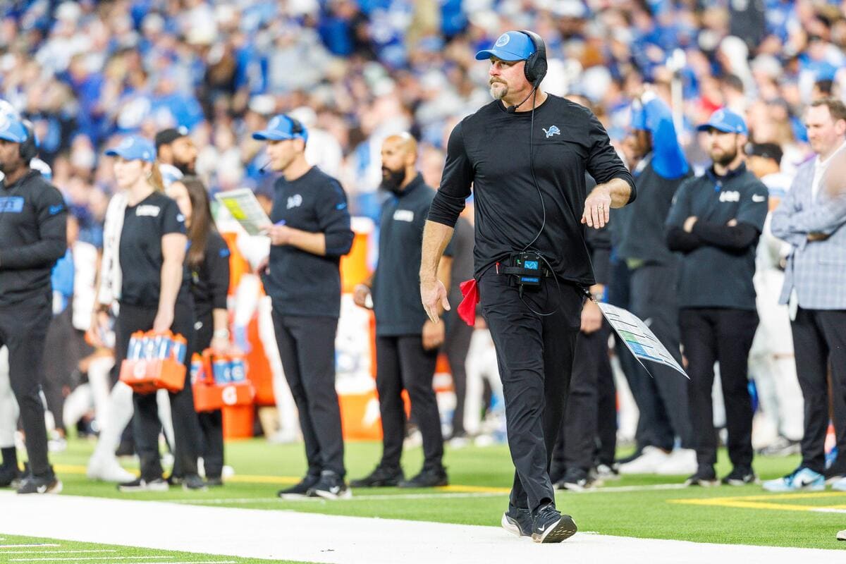 Lions head coach dan Campbell walking on the sidelines during a game.