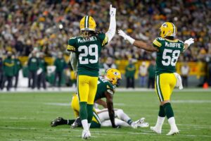 Green Bay Packers defenders Xavier McKinney and Isaiah McDuffie celebrate a good defensive play.