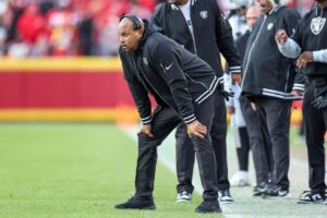 Las Vegas Raiders head coach Antonio Pierce bends over with his hands on his knees.