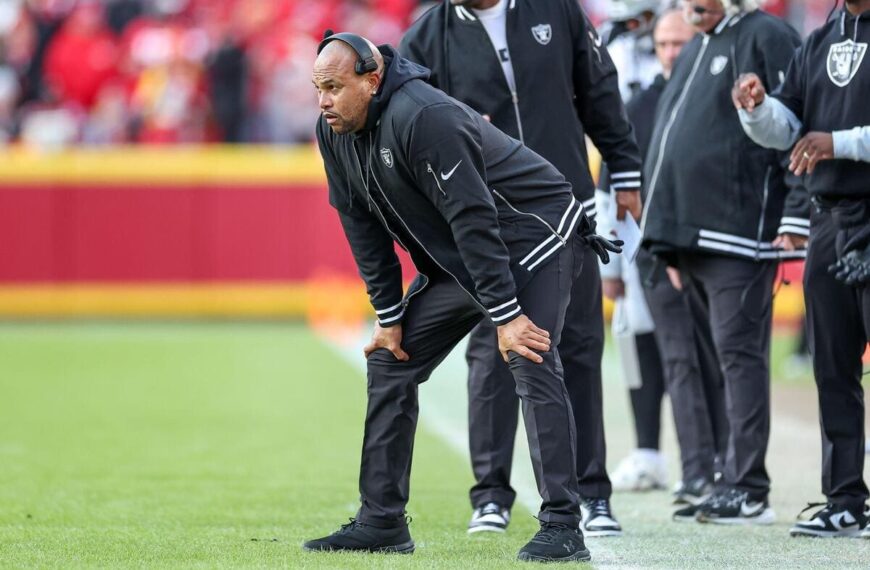 Las Vegas Raiders head coach Antonio Pierce bends over with his hands on his knees.