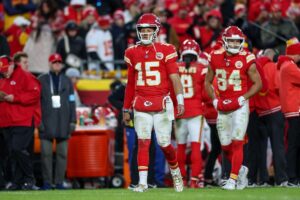 Kansas City Chief quarterback Patrick Mahomes with teammates in the background.