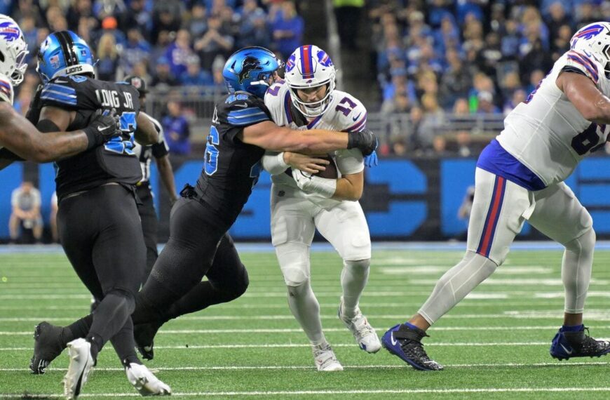 Buffalo Bills quarterback Josh Allen being tackled by a Detroit Lions defender.