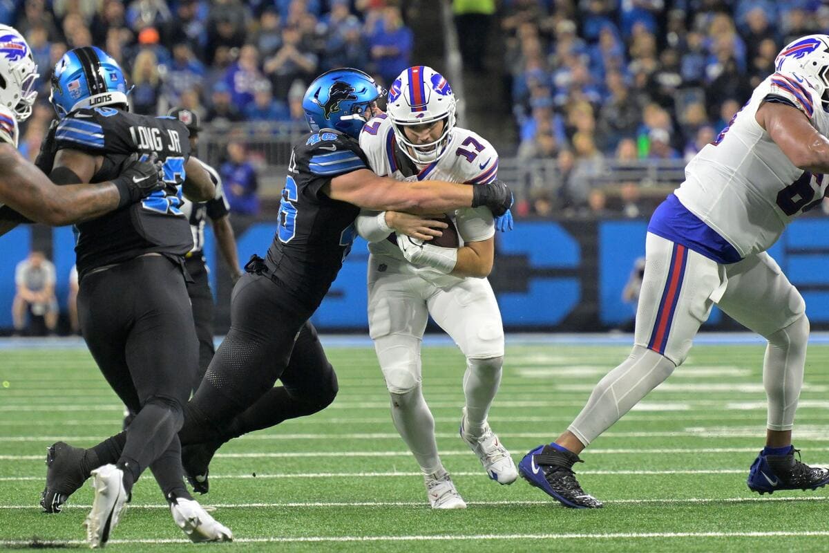 Buffalo Bills quarterback Josh Allen being tackled by a Detroit Lions defender.