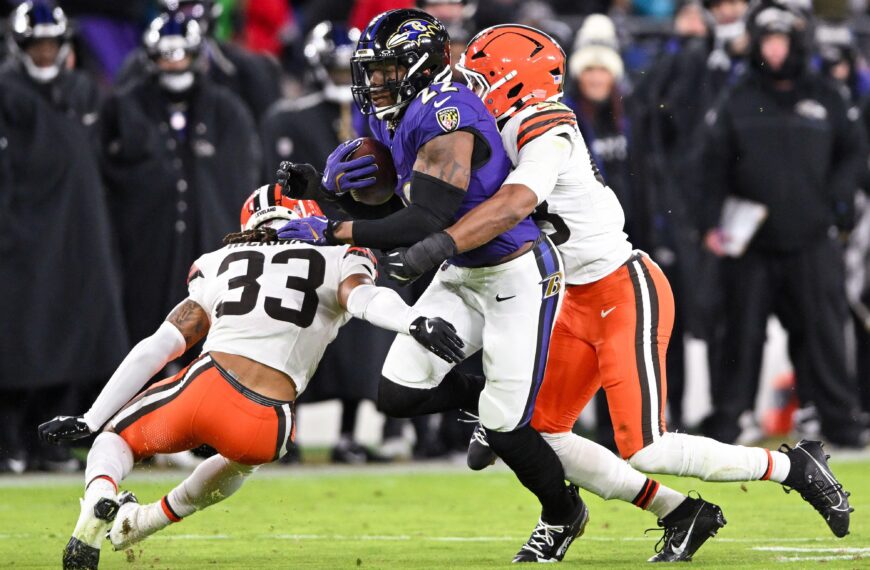 Baltimore Ravens running back Derrick Henry being tackled by two members of the Cleveland Browns.