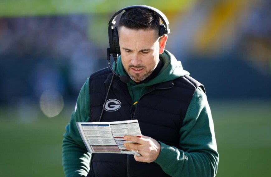 Green Bay Packers head coach Matt LaFleur looks at a play sheet.