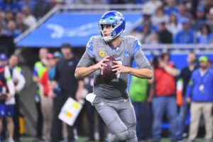 Detroit Lions quarterback Jared Goff runs with a football.